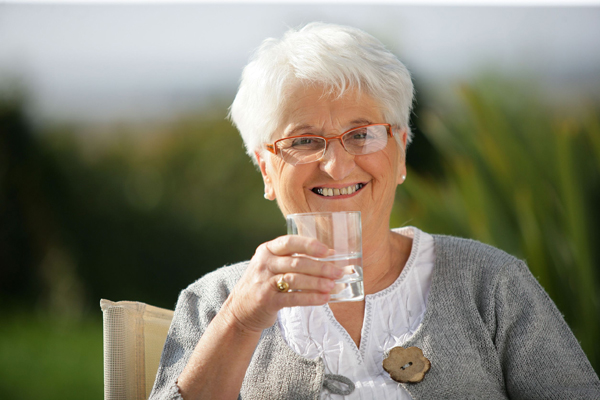Happy older woman with a glass of water 14204004 L
