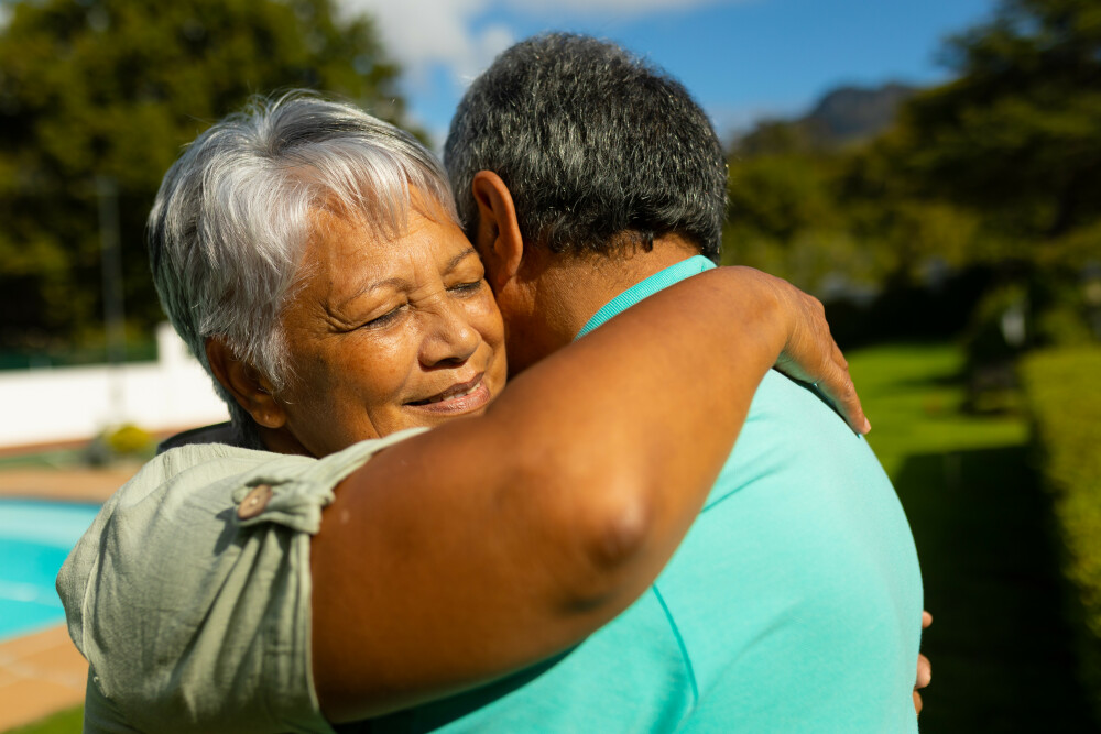 Older couple hugging outside 