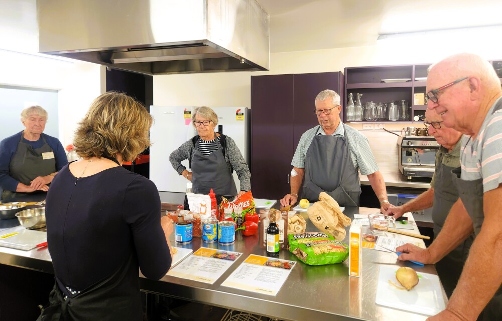 Older Adults standing in kitchen preparing food