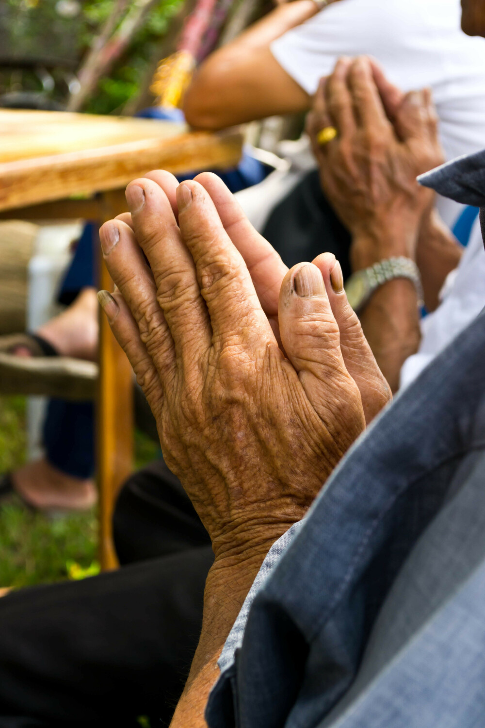 Older hands praying