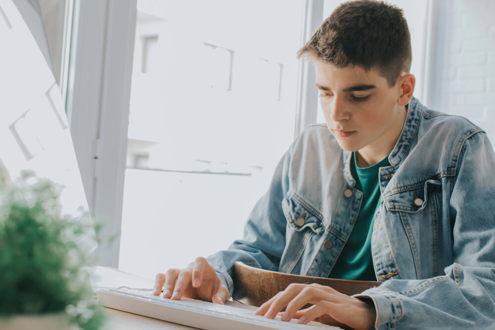 young male sitting at a laptop typing (2)